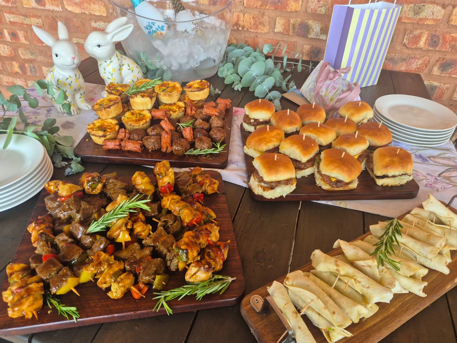 Wooden boards of kebabs, sliders, mini quiches and wraps